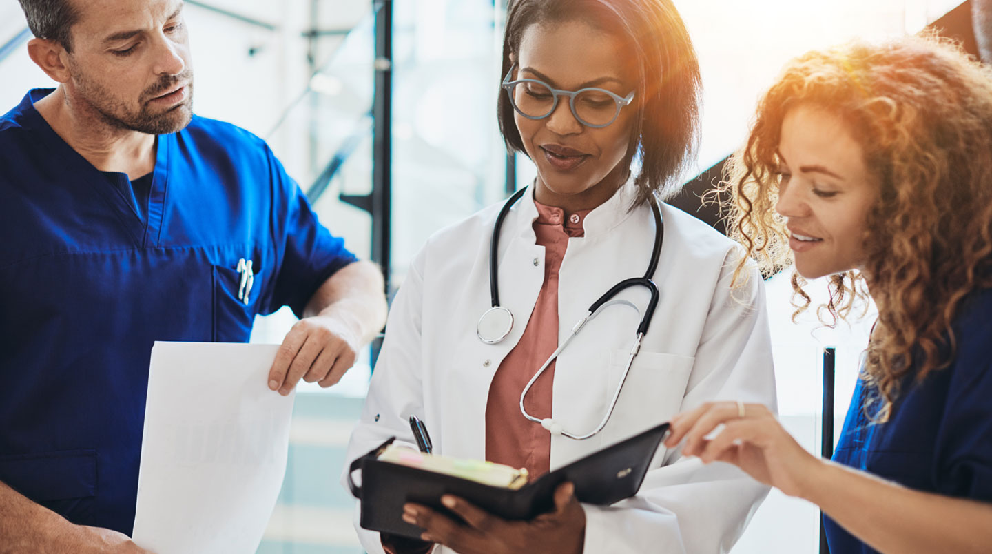 Médecin libéral travaillant dans son cabinet de consultation moderne avec bureau clair, stéthoscope et ordonnancier, lumière naturelle douce